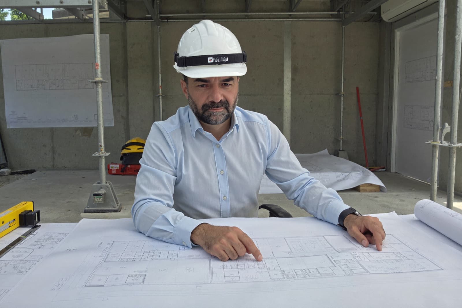 Qais Wakil prüft Baupläne auf der Baustelle